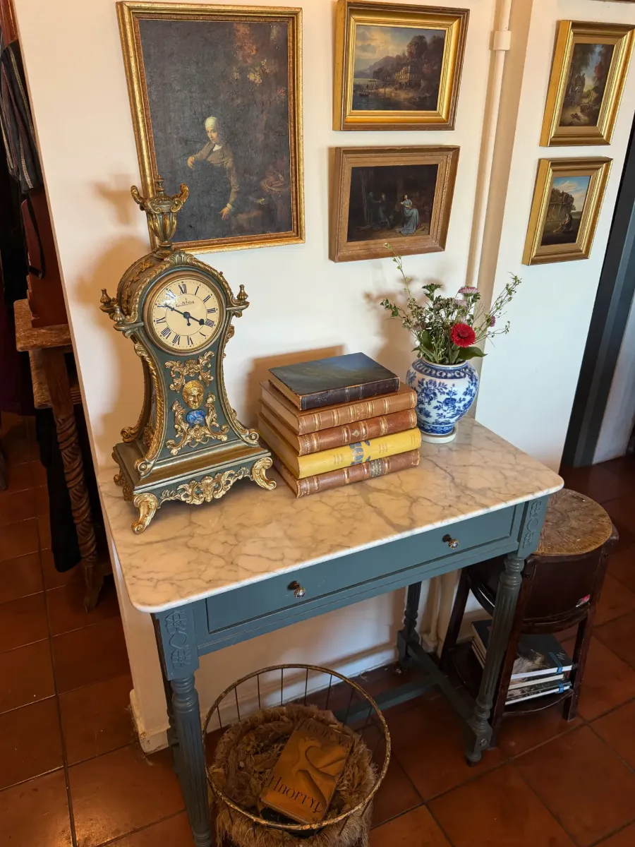 Still life of gilded clock, leather books and porcelain vase